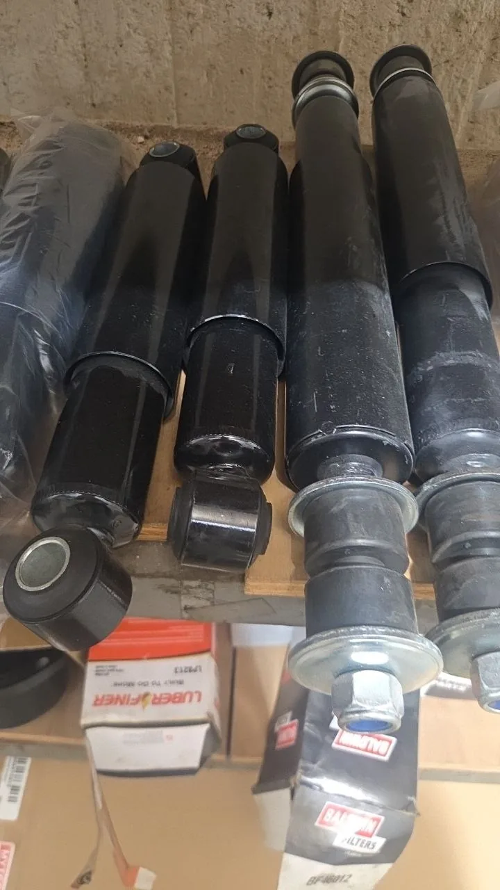 Original photo of assorted truck shock absorbers with different mounting ends; part numbers not visible
